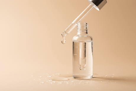 Flacon compte-gouttes et gouttes d'eau, hydratation d'une peau grasse déshydratée